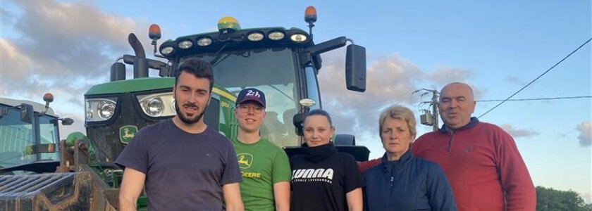 Eleven og vertsfamilien foran en traktor på et fransk jorde - Klikk for stort bilde